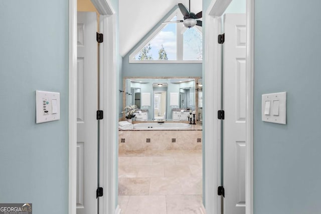 bathroom with tile patterned floors, tiled bath, and ceiling fan