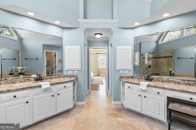 bathroom featuring vanity, a shower with shower door, crown molding, and a high ceiling