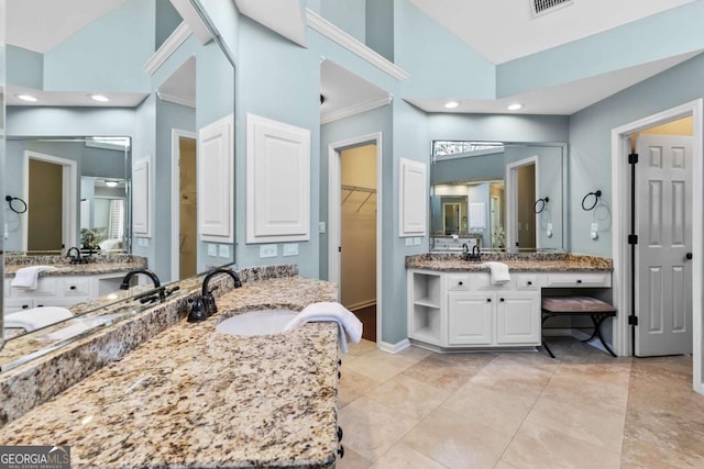 bathroom with a high ceiling, vanity, and ornamental molding