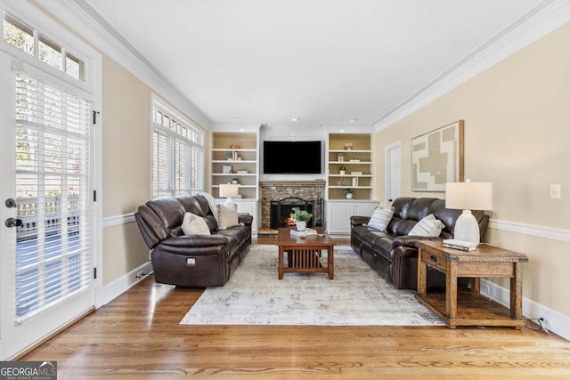 living room featuring hardwood / wood-style flooring, built in features, and crown molding