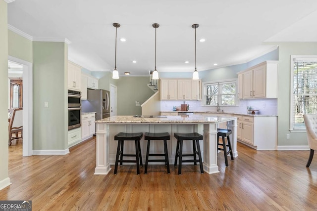 kitchen with decorative light fixtures, a center island, appliances with stainless steel finishes, and tasteful backsplash