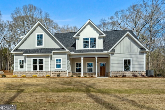 view of front of house featuring board and batten siding, brick siding, and roof with shingles