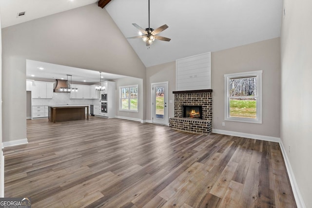 unfurnished living room with dark wood finished floors, a healthy amount of sunlight, and a fireplace