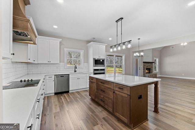 kitchen with appliances with stainless steel finishes, a sink, white cabinetry, and decorative backsplash