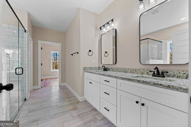 bathroom featuring baseboards, a shower stall, visible vents, and a sink