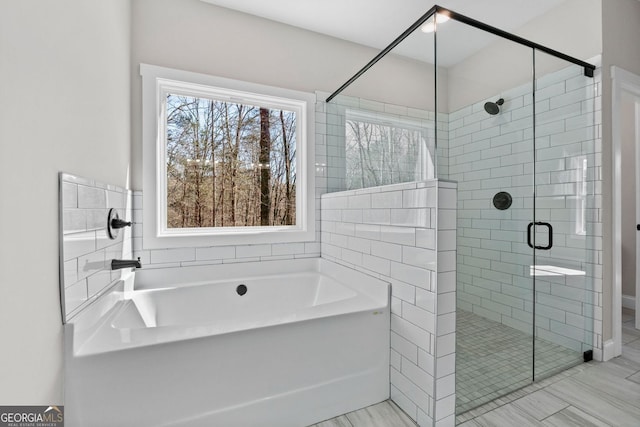 full bath featuring a stall shower and a garden tub