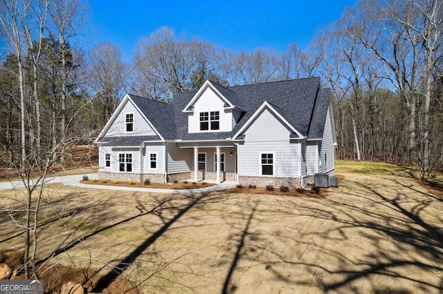 view of front of house with central AC, a porch, and roof with shingles