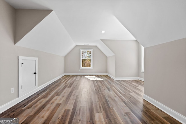 additional living space with vaulted ceiling, baseboards, and wood finished floors