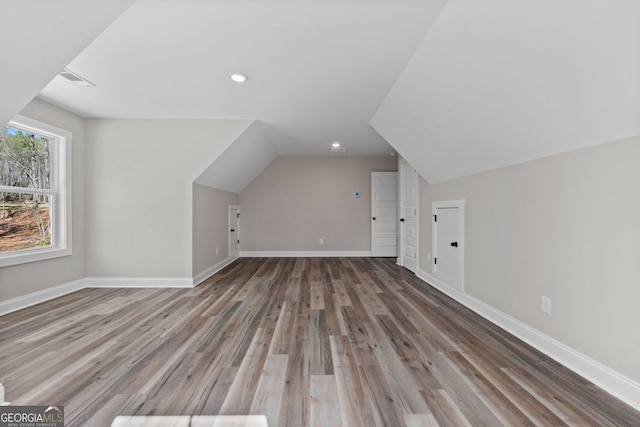 additional living space featuring lofted ceiling, recessed lighting, baseboards, and wood finished floors