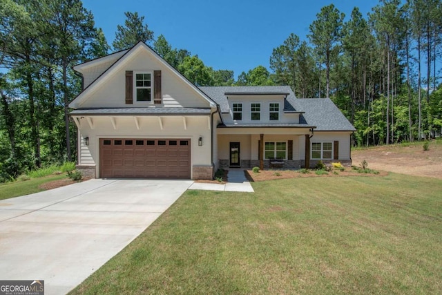 view of front of house with a porch, a garage, and a front lawn