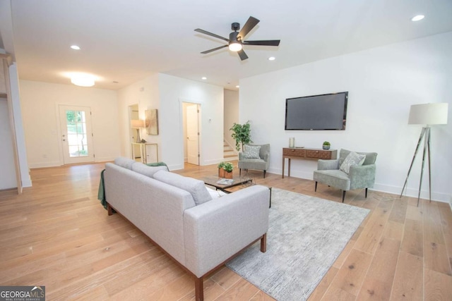 living room with light hardwood / wood-style flooring and ceiling fan