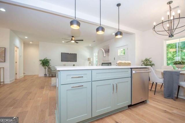 kitchen featuring stainless steel dishwasher, ceiling fan with notable chandelier, a healthy amount of sunlight, a kitchen island, and hanging light fixtures