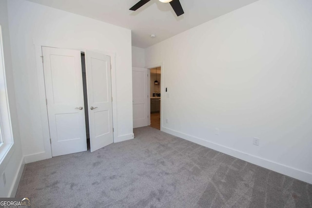 unfurnished bedroom with ceiling fan and light colored carpet