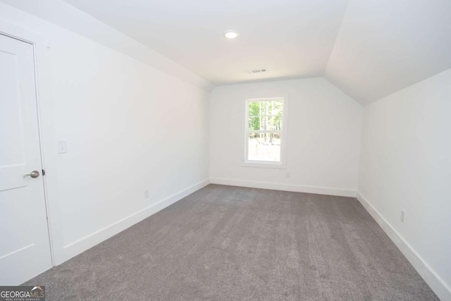 additional living space featuring carpet flooring and vaulted ceiling