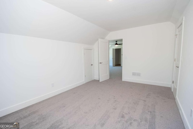 additional living space with ceiling fan, lofted ceiling, and light carpet