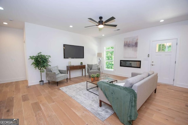 living room with light hardwood / wood-style floors and ceiling fan