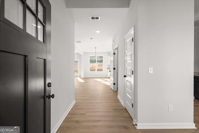 corridor with light hardwood / wood-style floors