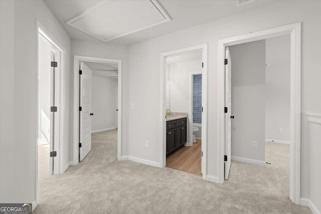 hallway featuring sink and light carpet