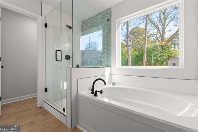 bathroom featuring hardwood / wood-style flooring and separate shower and tub