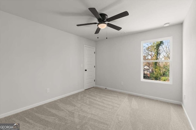 carpeted spare room featuring ceiling fan