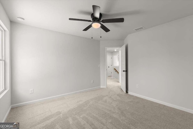 interior space with ceiling fan and light colored carpet