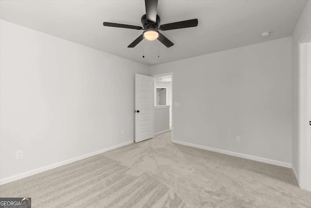 carpeted spare room featuring ceiling fan