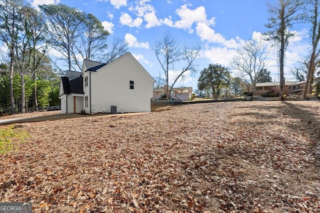 view of side of property with a garage and central AC unit