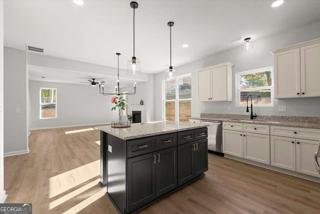 kitchen with white cabinetry, dishwasher, ceiling fan, pendant lighting, and a kitchen island