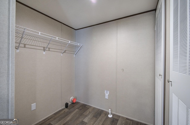 laundry area with ornamental molding and dark wood-type flooring