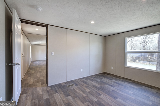 unfurnished bedroom featuring a textured ceiling and dark wood-type flooring