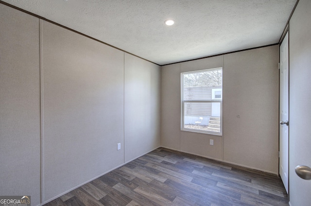 spare room with hardwood / wood-style floors and a textured ceiling