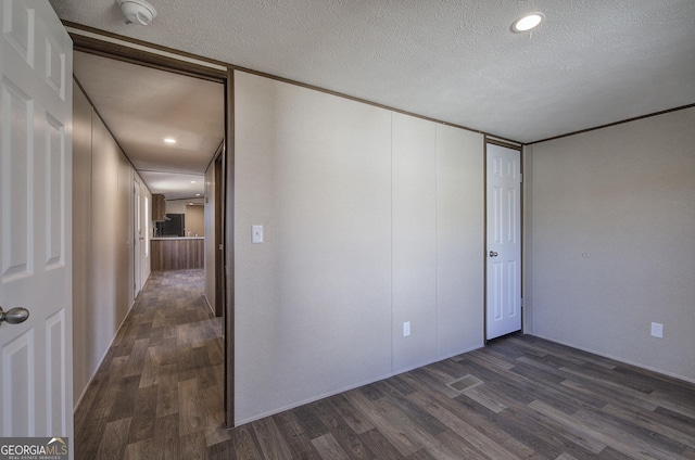 interior space with a textured ceiling and dark hardwood / wood-style floors