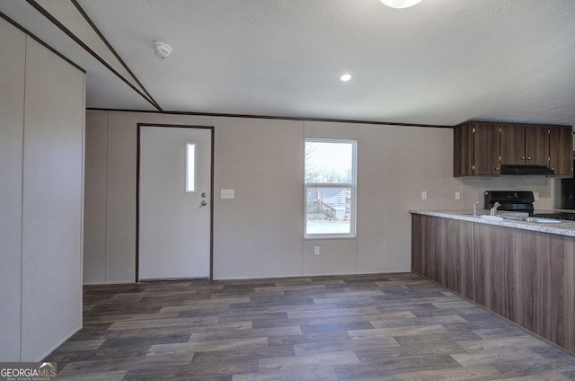 kitchen with a textured ceiling, dark hardwood / wood-style flooring, dark brown cabinetry, and black range oven