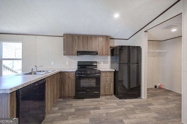 kitchen featuring hardwood / wood-style floors, sink, crown molding, and black appliances