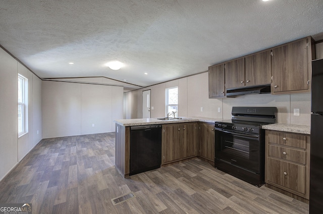 kitchen featuring black appliances, a textured ceiling, sink, and dark wood-type flooring