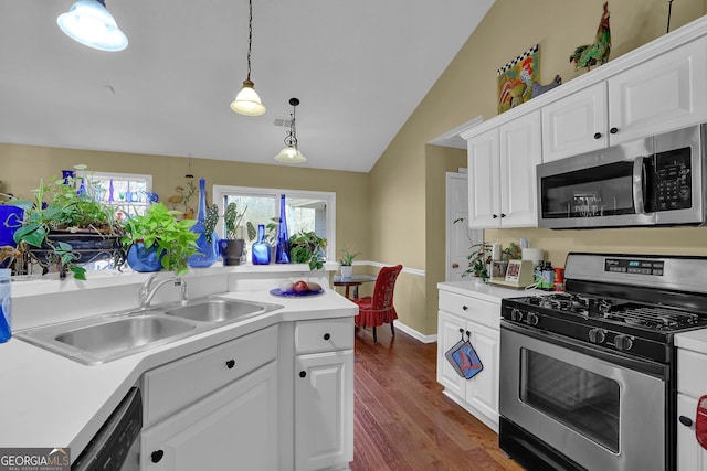 kitchen with white cabinets, appliances with stainless steel finishes, lofted ceiling, and sink