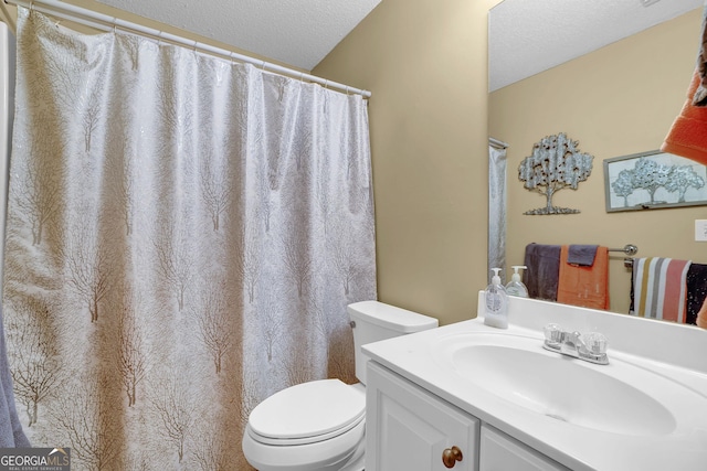 bathroom featuring vanity, a textured ceiling, and toilet