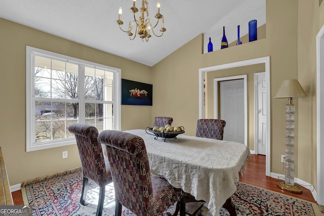 dining space featuring a notable chandelier, wood-type flooring, and vaulted ceiling