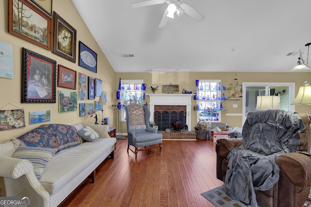 living room featuring a wealth of natural light, a fireplace, ceiling fan, and hardwood / wood-style floors