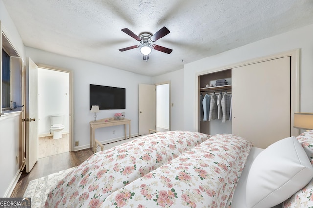 bedroom featuring a textured ceiling, ceiling fan, wood-type flooring, connected bathroom, and a closet