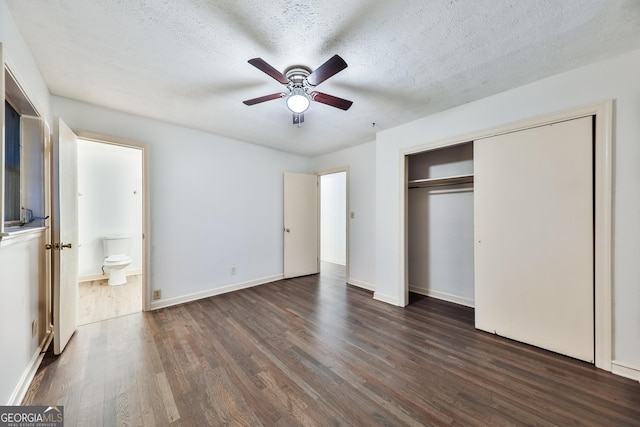 unfurnished bedroom featuring ensuite bath, a textured ceiling, ceiling fan, dark hardwood / wood-style floors, and a closet