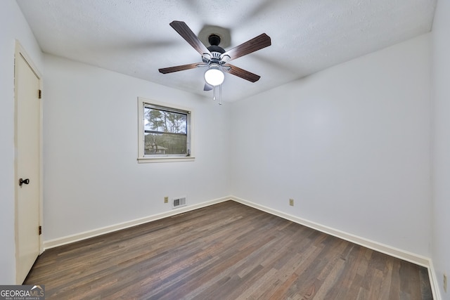 unfurnished room with a textured ceiling, ceiling fan, and dark wood-type flooring