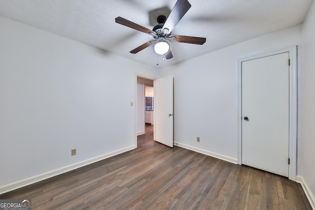 unfurnished bedroom with dark hardwood / wood-style flooring and ceiling fan