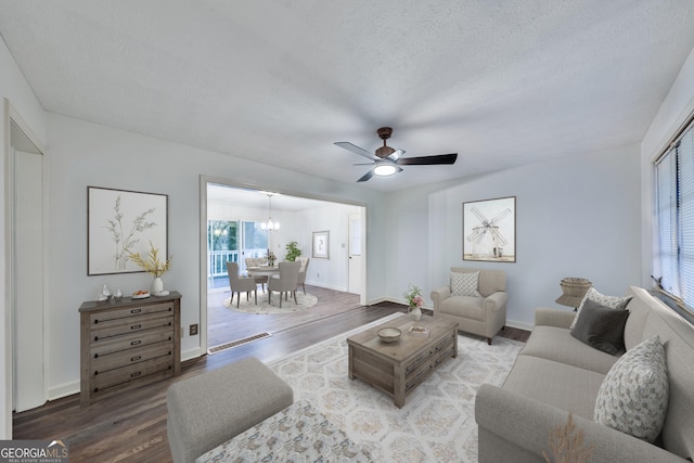 living room with a textured ceiling, hardwood / wood-style floors, and ceiling fan with notable chandelier