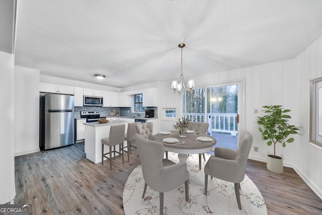 dining area featuring an inviting chandelier, crown molding, and light hardwood / wood-style flooring