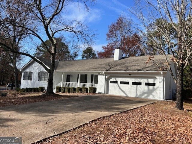 ranch-style house with a porch and a garage