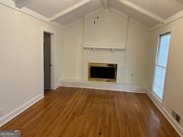 unfurnished living room with dark wood-type flooring, a fireplace, and lofted ceiling with beams