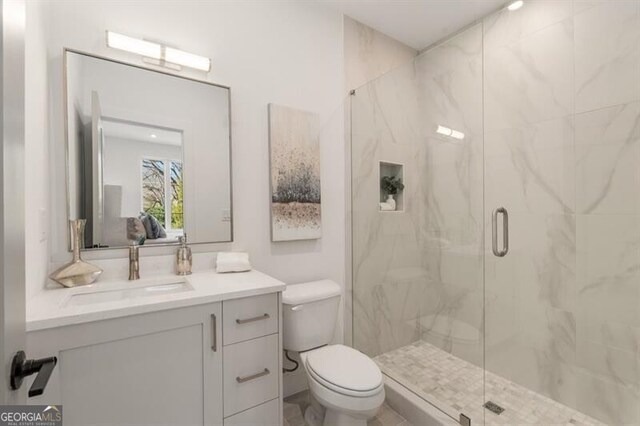 bathroom featuring vanity, toilet, and walk in shower