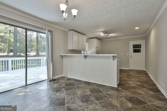 kitchen featuring a breakfast bar, white cabinets, a textured ceiling, kitchen peninsula, and a chandelier