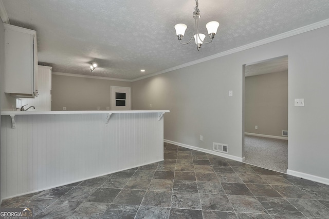 kitchen with kitchen peninsula, a kitchen breakfast bar, a textured ceiling, an inviting chandelier, and white cabinets